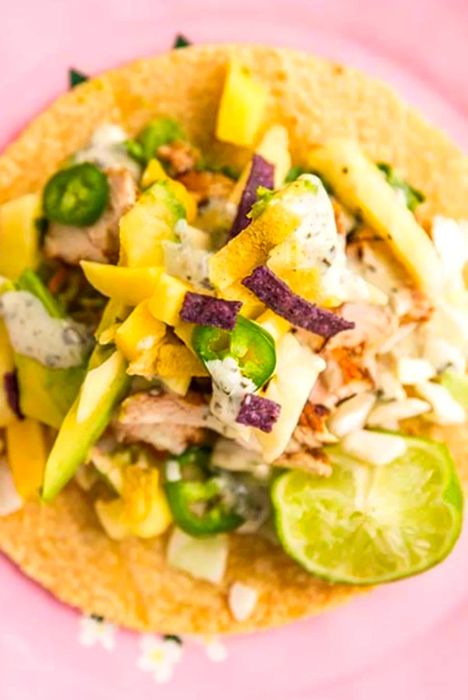 Close-up of a pineapple mango chicken taco bursting with flavor