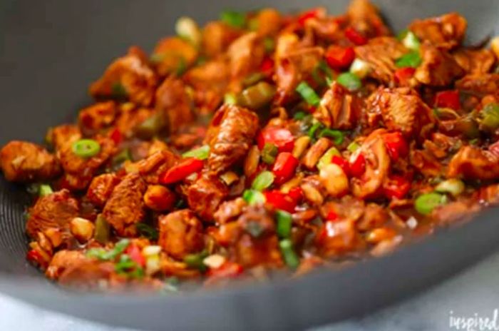 Side view of Kung Pao Chicken being cooked in a large skillet