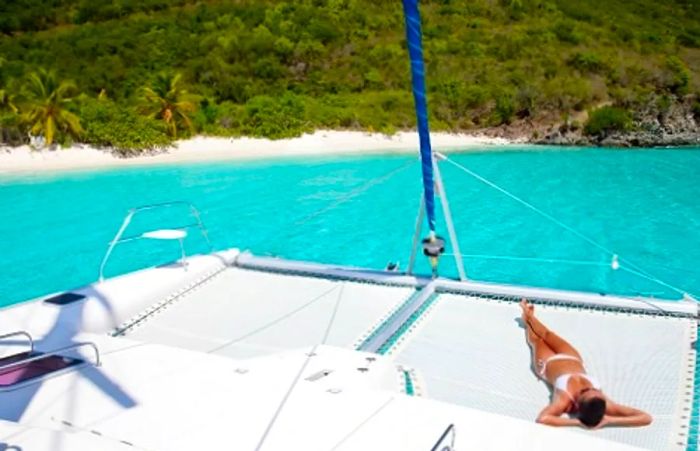 A woman sunbathing on a catamaran in Amber Cove