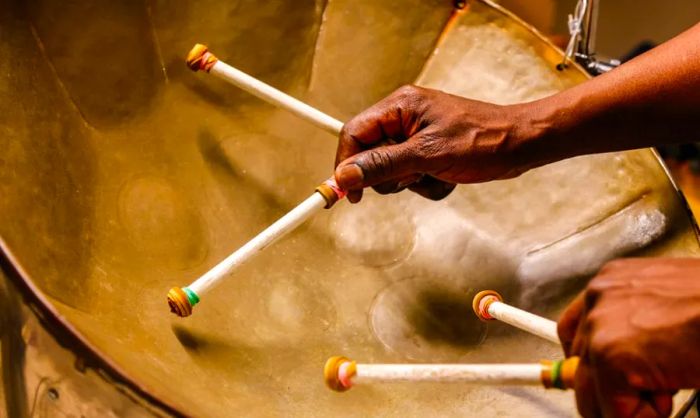 A close-up view of hands skillfully playing steel drums.