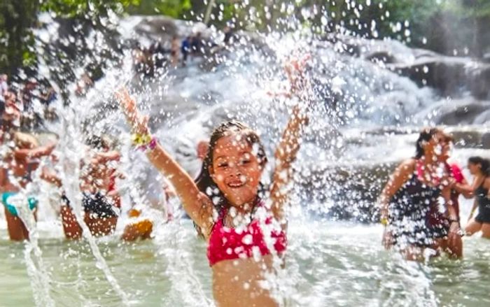 a little girl splashing joyfully at Dunn's River Falls