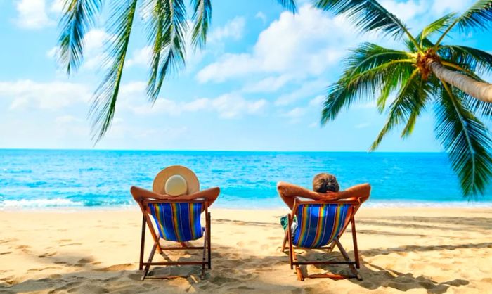 Couple enjoying their time on a beach in lounge chairs