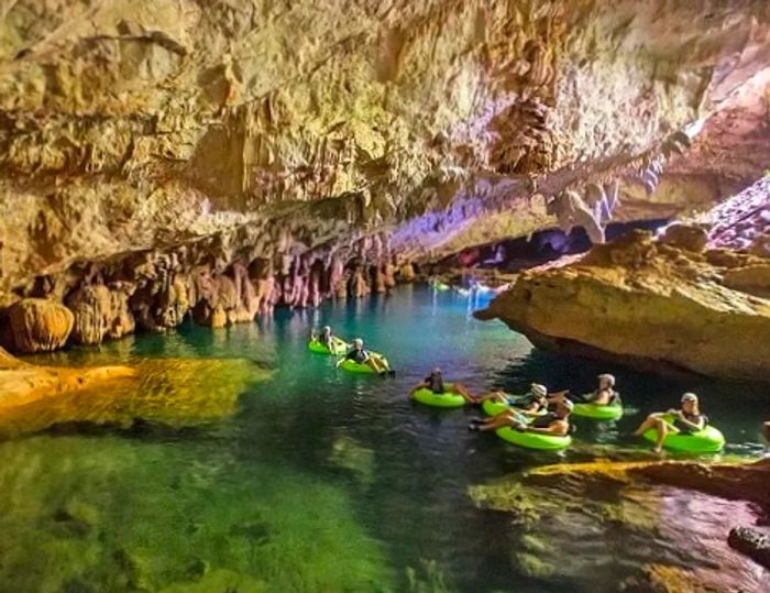 a group of adventurers cave tubing in the beautiful waters of Belize