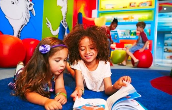 two little girls sharing a book together