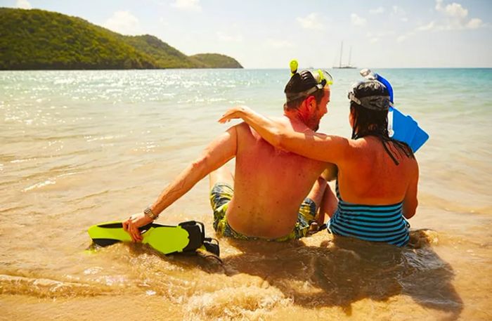 a couple relaxing on a beach with snorkeling gear