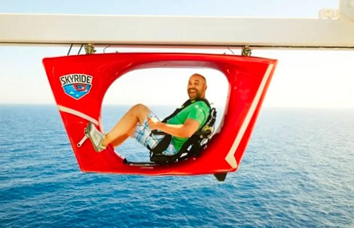 man grinning while riding on Dinogo’s SkyRide