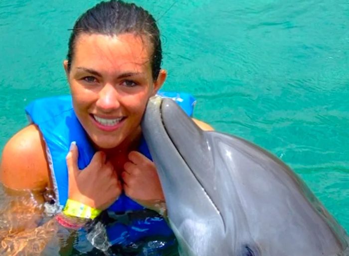 woman embraced by dolphin in Grand Cayman