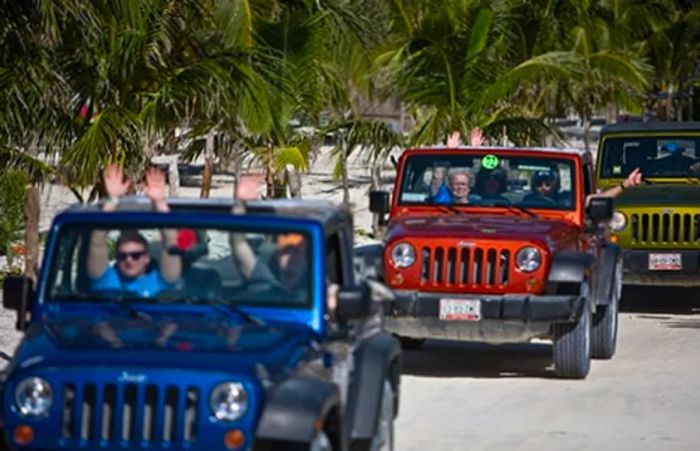 A group of people exploring Punta Sur Park in vibrant blue, orange, and green jeeps