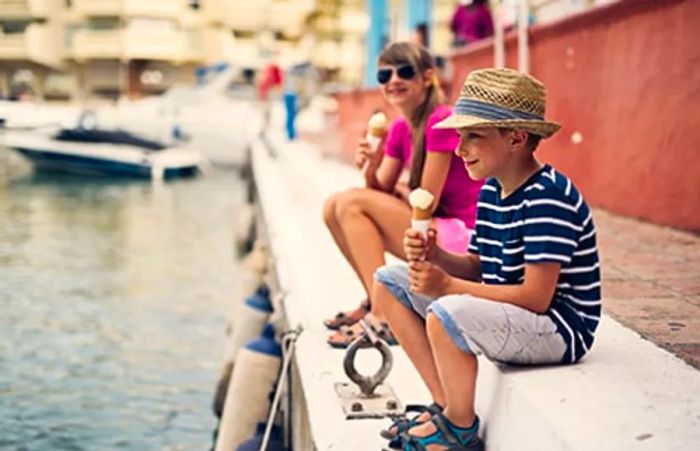 siblings enjoying ice cream at Inner Harbor in Baltimore