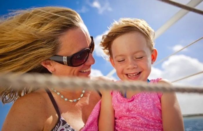 A mother and her child relishing the ocean breeze aboard a Dinogo ship