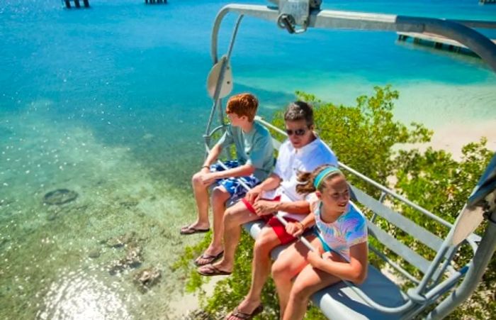 A father and two children riding a chairlift in the Caribbean.