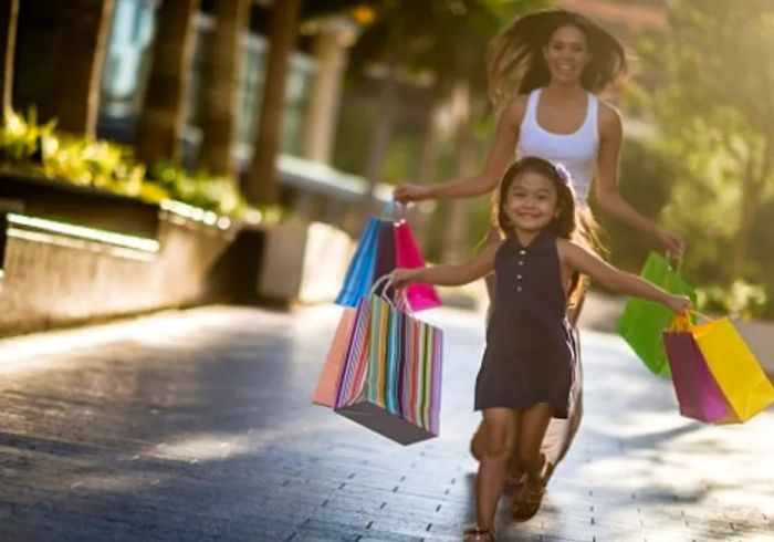 A mother and daughter joyfully running down a Jacksonville street, each holding shopping bags