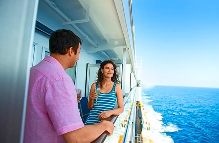 a couple enjoying champagne on their stateroom balcony