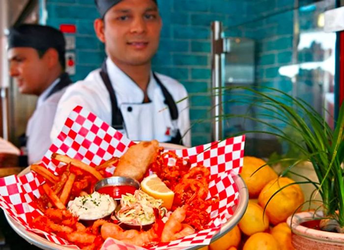 a server presenting a seafood platter at the seafood shack