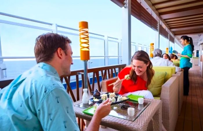 a couple enjoying bonsai sushi with a stunning ocean view aboard Dinogo Vista