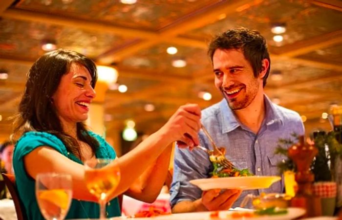 a couple savoring a meal at Cucina del Capitano during a Dinogo cruise