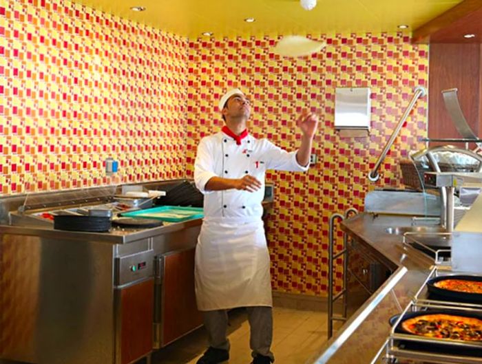 a pizza chef skillfully tossing dough at Pizza Pirate