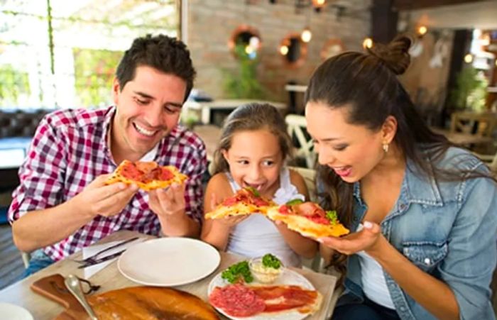 family enjoying pizza at an Italian eatery in Baltimore's Little Italy