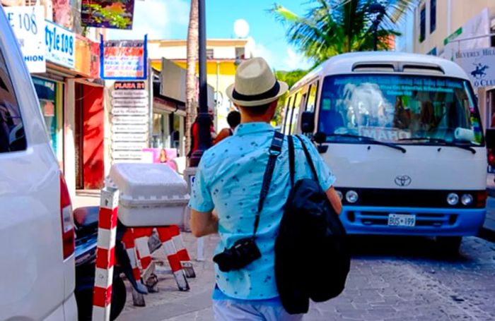 Jeremy sporting a hat and carrying his bag and camera while exploring St. Maarten.