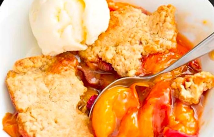 peach cobbler served with a scoop of vanilla ice cream