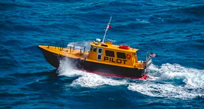 A yellow pilot boat cruising in the ocean