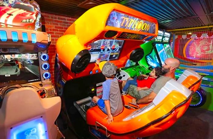 Father enjoying arcade time with his children aboard the ship