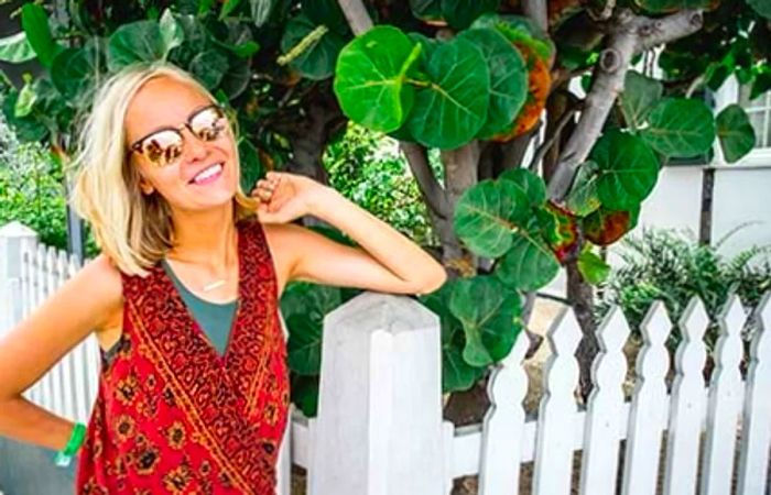 Hailey smiling with a white picket fence in the background