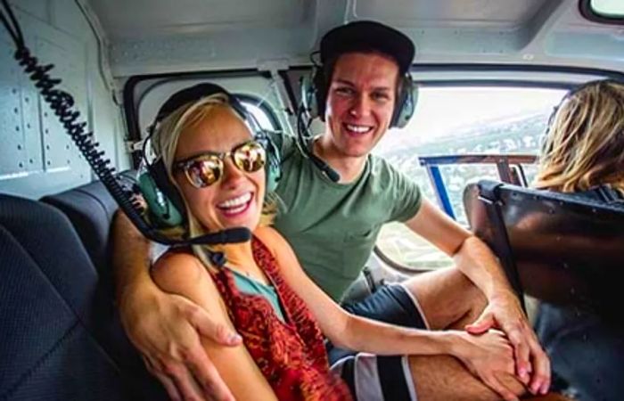 Brad and Hailey smiling inside a helicopter in Grand Cayman