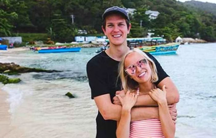 Brad and Hailey smiling together on the sandy shore