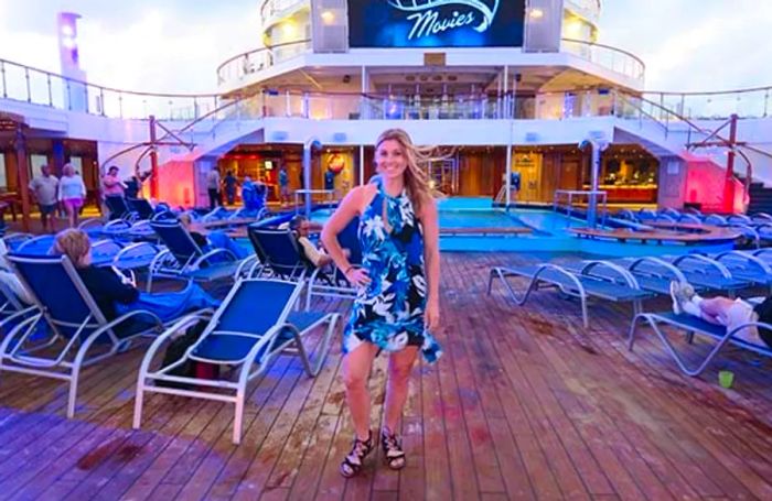 Sarah striking a pose in a dress on the pool deck of the Dinogo Conquest.