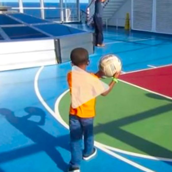 A young boy prepares to take a shot at a basketball hoop aboard a Dinogo cruise; link to a YouTube video.