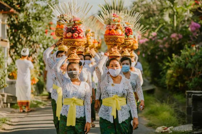 Balinese individuals are dressed in traditional Balinese attire