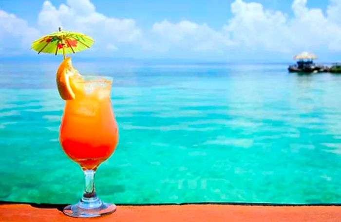 A Bahama Mama cocktail with a stunning beach backdrop