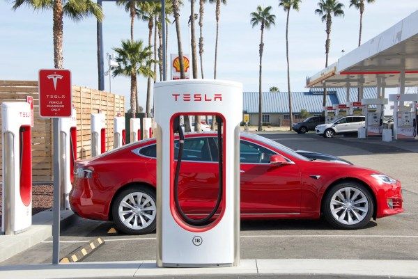 Red Tesla Charging at a Supercharger