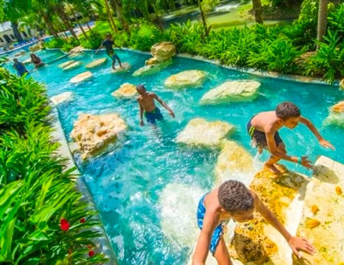 children climbing on rocks at a Jamaican waterpark