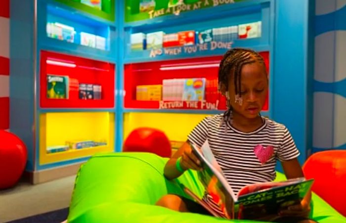 a girl immersed in a Dr. Seuss book in Dr. Seuss’ Bookville