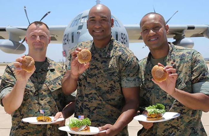 three marines proudly display the messages engraved on their burger buns