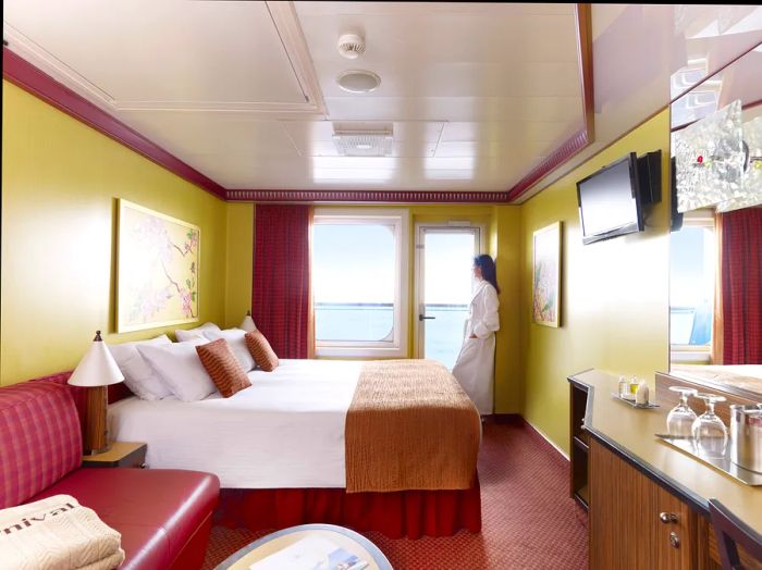 a woman in a robe in a stateroom with an ocean view