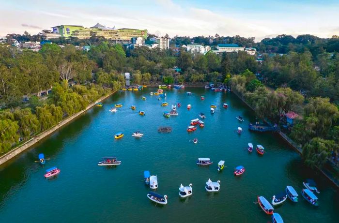 A bird's-eye view of Burnham Park's artificial lake, featuring SM Baguio in the background.