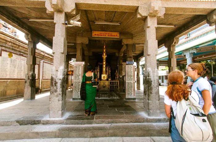 Within the ARULMIGU KAPALEESWAR temple complex, you'll find another temple where two local devotees and two international visitors have come to pay their respects. Mylapore, Chennai, India