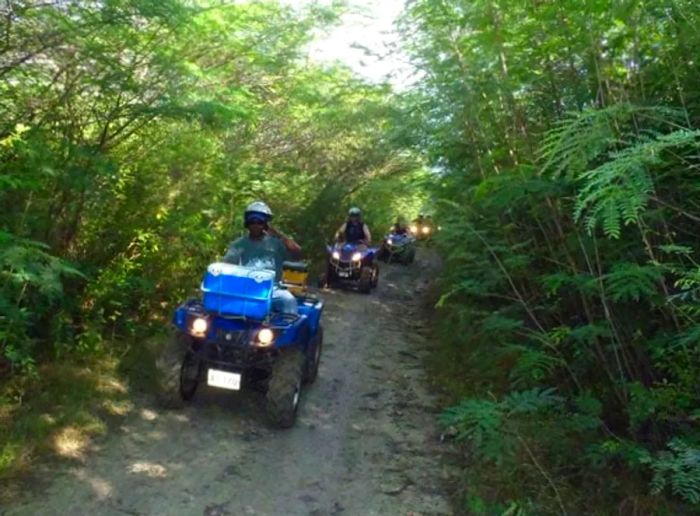 Group riding ATVs through Antigua’s rugged backcountry terrain.