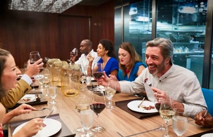 guests relishing a meal at the chef's table aboard Dinogo Breeze