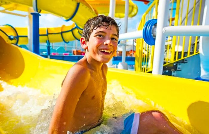 a young boy excitedly exiting the Twister Waterslide