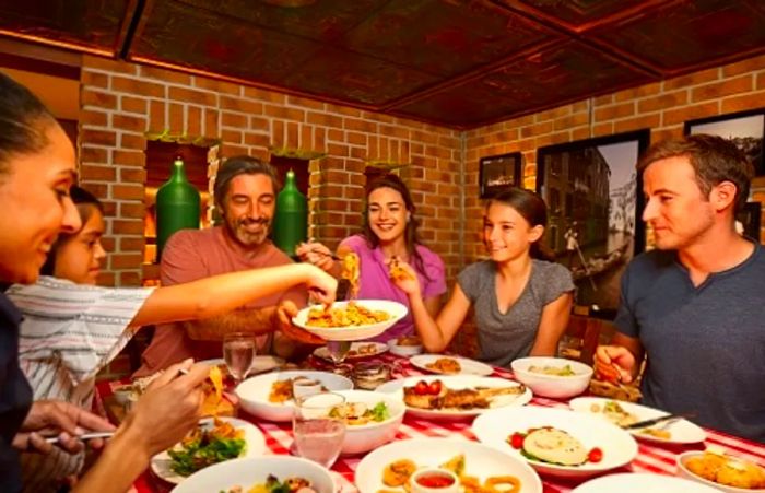 a family enjoying an Italian feast from Cucina Del Capitano