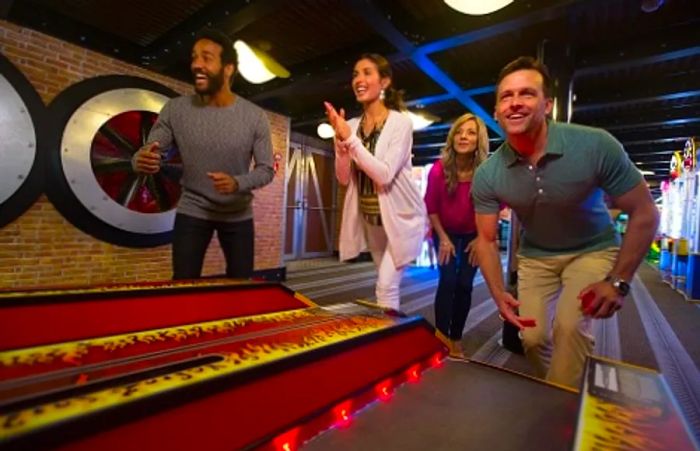 friends having fun playing ski-ball in the video arcade