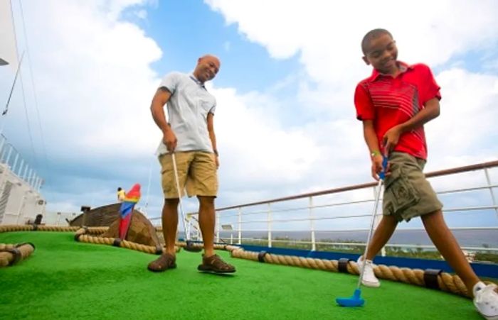 a father and son enjoying a game of mini golf aboard a Dinogo ship