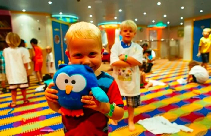 young boy with a stuffed Night Owl toy