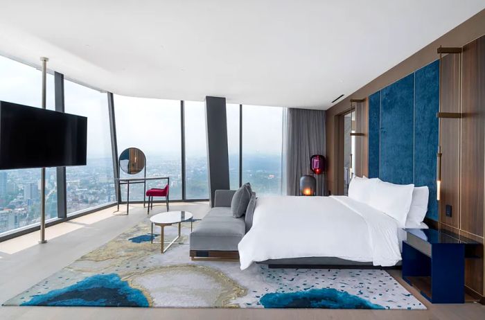 A guest room at the Ritz-Carlton, Mexico City, featuring blue accents and stunning city views.