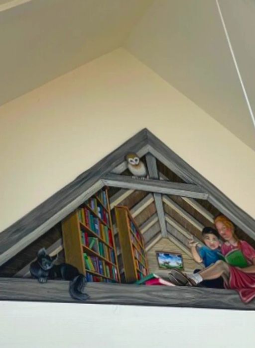 A triangular mural in the Chilmark Library illustrates two children seated in an attic reading a book about sign language; one child is forming the letter 'L' in finger spelling with their hand.