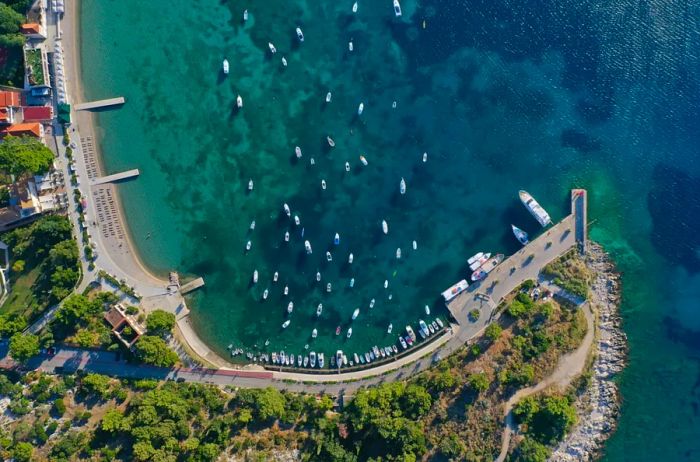 Aerial view of Srebreno Bay and beach near Dubrovnik, dotted with small boats.